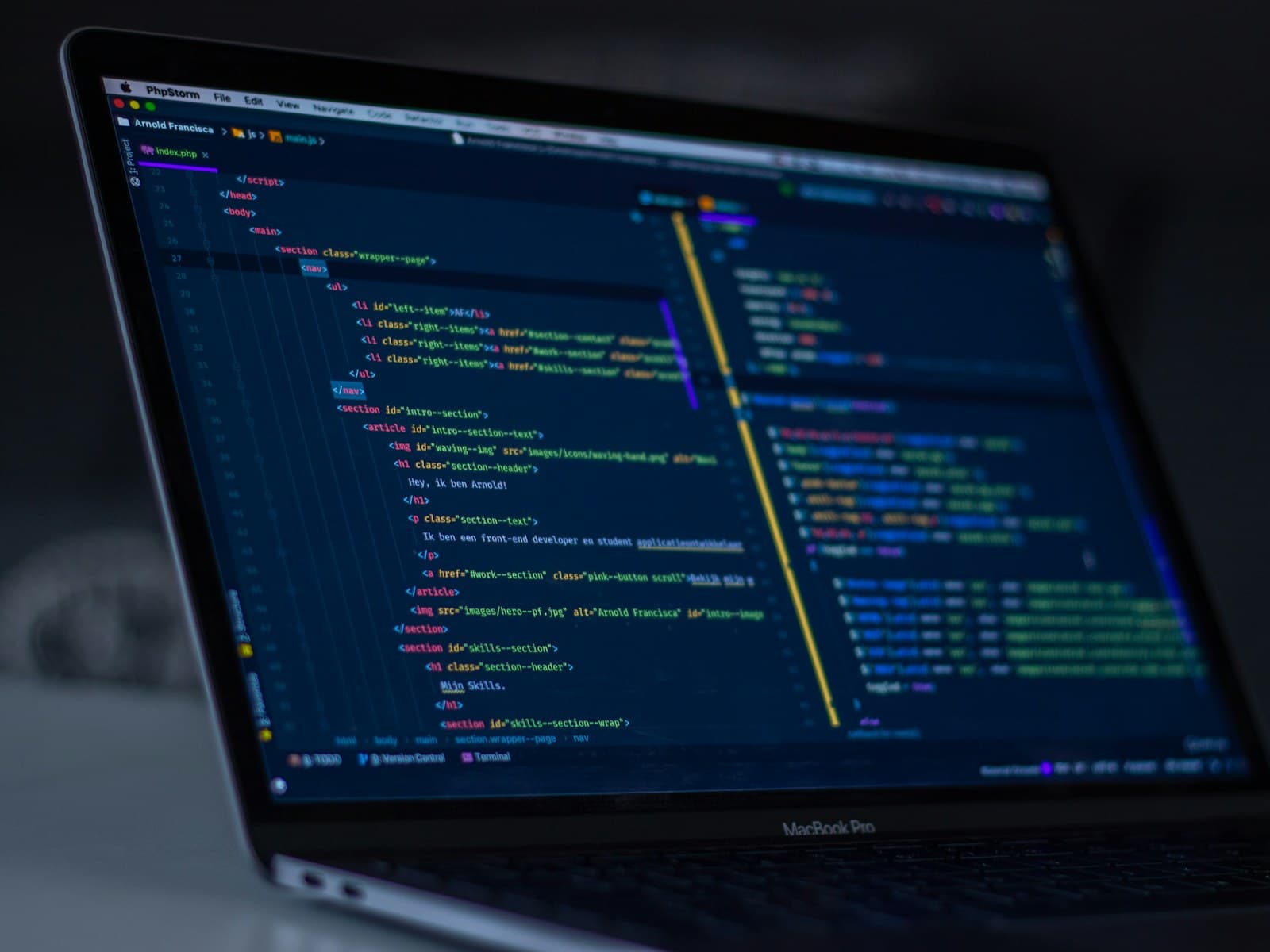 A laptop screen filled with lines of code in a dark room